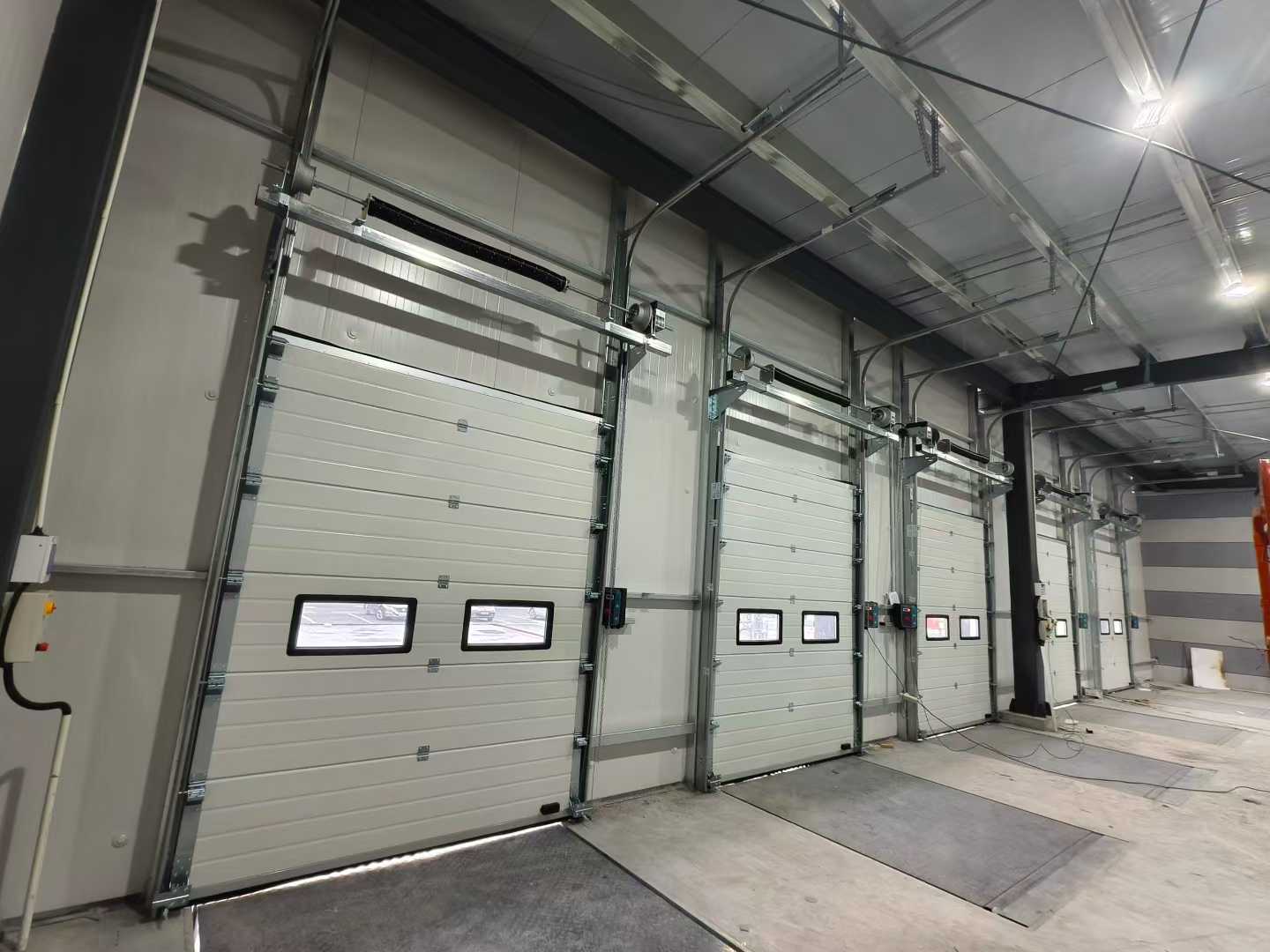 Pošiljka industrijskih sekcijskih vrat in nakladalnih naprav za skladiščne projekte